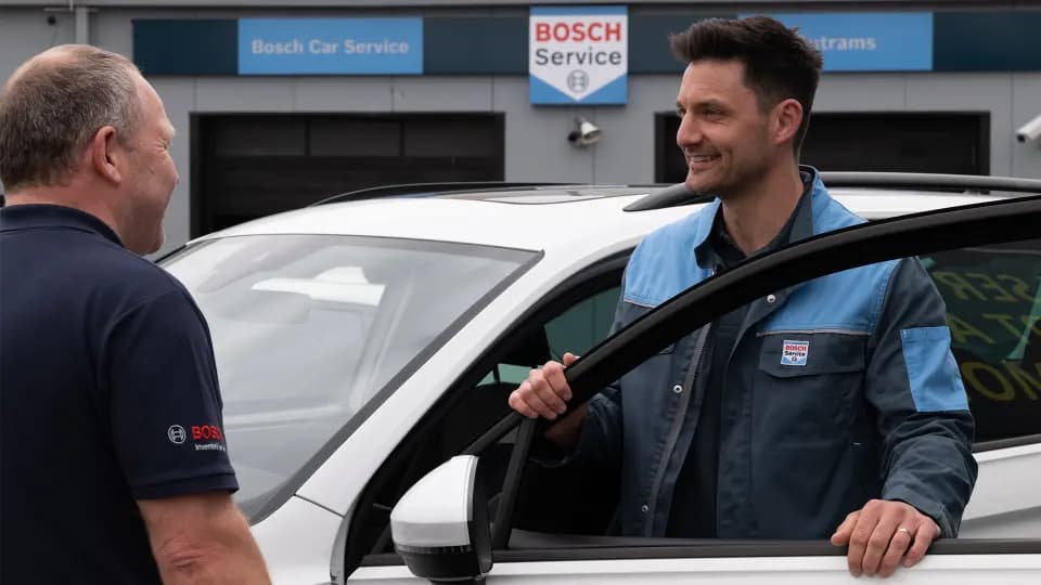 A Bosch Car Service technician talking a customer through their car